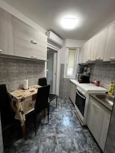 a kitchen with a table and a sink and a stove at ENE Apartament Oradea in Oradea