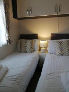 two beds sitting next to each other in a room at No1 Borwick Lakes in Carnforth