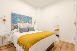 a bedroom with a large bed with a painting on the wall at Green-Apartments Pleno Centro in Seville