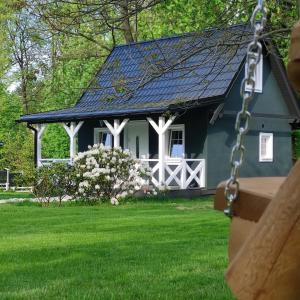 uma casa azul com um telhado solar num quintal em Domek pod Karpaczem em Milków