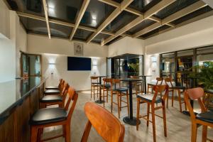 a bar with wooden chairs and tables in a restaurant at Kibo Palace Hotel Moshi in Moshi
