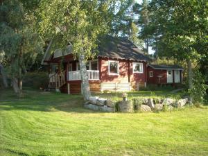 a log cabin with a tree in front of it at Uttis Home in Nauvo