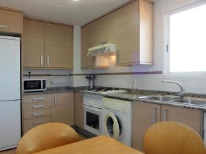 a kitchen with wooden cabinets and a sink and a dishwasher at Alojamiento ciudad las artes in Valencia