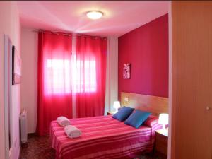 a red bedroom with a bed with towels on it at Alojamiento ciudad las artes in Valencia
