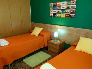 two beds in a room with green and orange at Alojamiento ciudad las artes in Valencia