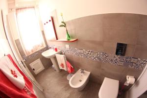 La salle de bains est pourvue de toilettes blanches et d'un lavabo. dans l'établissement IL CIELO IN UNA STANZA, à Balestrate