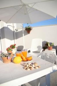 una mesa blanca con frutas y verduras y una sombrilla en IL CIELO IN UNA STANZA, en Balestrate