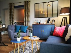 - un salon avec deux chaises bleues et une table dans l'établissement Chambres d'hôtes "Le Clos de la Baie", à Paimpol