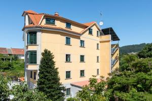 a tall yellow building with a red roof at Hotel Cabo Festiñanza in Sanxenxo
