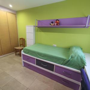 a bedroom with a bunk bed and a green wall at Piso Costa Peñíscola Inmomart in Peniscola