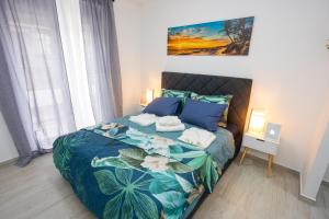 sypialnia z łóżkiem z niebieską i zieloną narzutą w obiekcie Luxury Apartments Love w mieście Kaštela