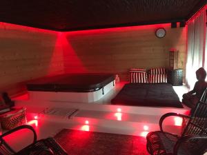 Cette chambre dispose d'un lit avec des lumières rouges. dans l'établissement les suites de bach, à Ploemeur