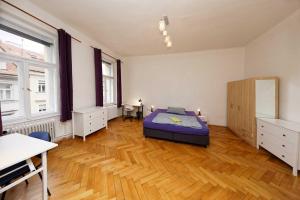 1 dormitorio con 1 cama y suelo de madera en Peter's Tower Apartments, en Praga