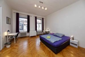 1 dormitorio con 1 cama, escritorio y ventanas en Peter's Tower Apartments, en Praga