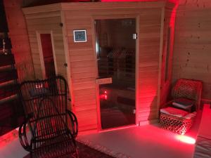 a red light on a dog house with a chair at les suites de bach in Ploemeur