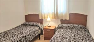 dwa łóżka w małym pokoju z oknem w obiekcie ACV - Marina Trebol II-2ªLínea Planta 4 (3 hab) w mieście Oropesa del Mar +13 zdjęć