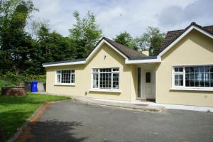 Casa amarilla con 2 ventanas y entrada en Brownstead Cottage, en Navan