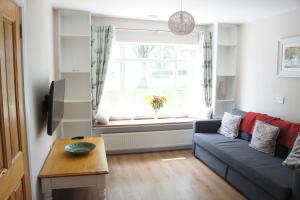 a living room with a blue couch and a window at Brownstead Cottage in Navan