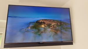 una pantalla de televisión con una foto de una casa en Valant Apartment en Bled