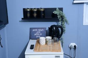 a kitchen counter with a cutting board with cups on it at אחוזת המייסדים in Beit Hillel