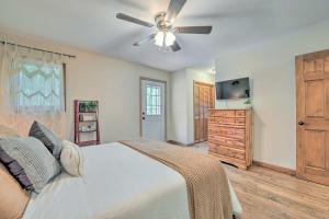 a bedroom with a bed with a ceiling fan and a dresser at Pet-Friendly Waynesville Home with Mountain Views! in Waynesville