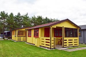 a row of yellow modular houses on a lawn at Poilsio nameliai Gulbes takas in Šventoji