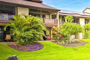 瓦克拉Chic Waikoloa Condo with Lanai and Complex Pools!的一座带绿草和树木的庭院