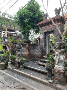 a garden with a stone building with trees and plants at Kubu Loris Residence in Ubud