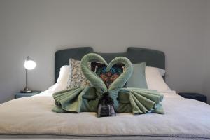 a bed with two towels and two swans on it at Hôtel confidentiel Le Grecale in Pianottoli-Caldarello