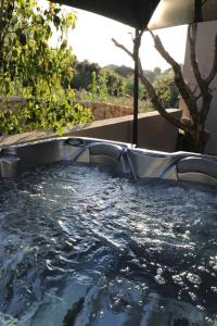 a hot tub with a metal frame in a yard at Hôtel confidentiel Le Grecale in Pianottoli-Caldarello