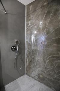 a shower in a bathroom with a stone wall at Hôtel confidentiel Le Grecale in Pianottoli-Caldarello