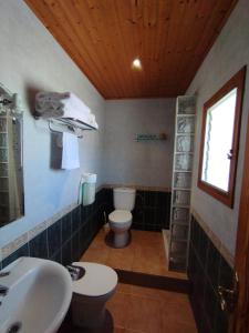 a bathroom with a sink and a toilet and a window at Hostal Restaurant Paca in Riumar