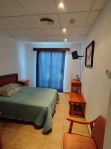 Schlafzimmer mit einem Bett und einem Tisch in der Unterkunft Hostal Restaurant Paca in Riumar