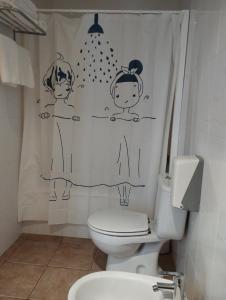 a bathroom with a shower curtain with two children on it at Hostal Restaurant Paca in Riumar