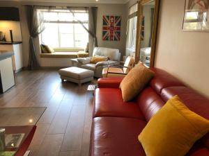 sala de estar con sofá de cuero marrón y mesa en 9 The Coach House in Rye, en Rye
