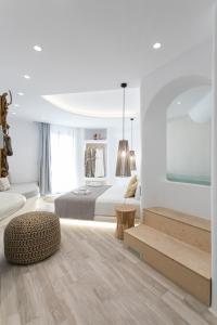 a white bedroom with a bed and a table at Majestique of Naxos boutique hotel in Naxos Chora