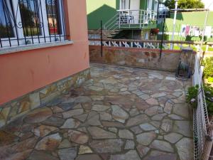 a stone patio outside of a house with a fence at A Pedriña Ribadeo in Ribadeo
