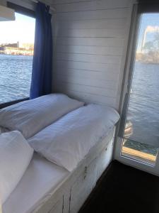 a bedroom with two beds in front of a window at Gemütliches Hausboot mit Kamin in Berlin in Berlin