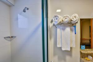 a bathroom with towels on a towel rack next to a shower at Comfort Mogi Guaçu in Mogi Guaçu