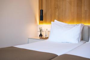 1 dormitorio con 1 cama con almohada blanca en Tempo FLH Hotels Lisboa, en Lisboa