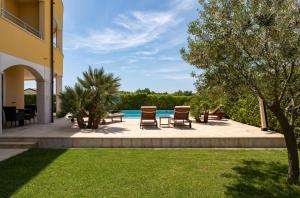 a patio with a table and chairs next to a pool at B&B Villa Oasa 1 in Rovinj