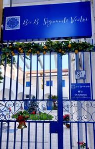 ein blaues Tor mit einem Schild mit Orangen drauf in der Unterkunft Suite FURORE in Aversa