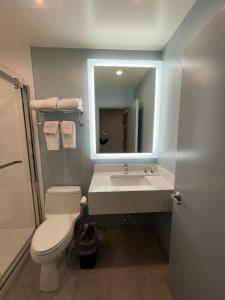 a bathroom with a sink and a toilet and a mirror at 112 Motel in Medford
