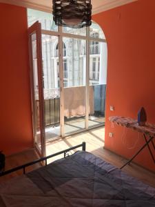 um quarto com uma cama e uma grande janela em Apartment White Magnolia em Batumi