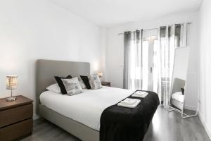 Un dormitorio blanco con una cama grande y una silla. en Just Sea, en Peniche