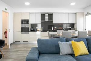 a living room with a blue couch and a kitchen at Just Sea in Peniche