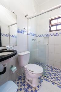 uma casa de banho com um WC e uma cabina de duche em vidro. em HOTELARE Pousada Bóra Morá em Ubatuba