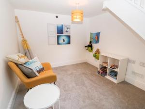 a living room with a chair and a table at Rothlea Flat 1 in Pwllheli