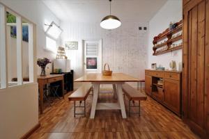 eine Küche mit einem Holztisch und Bänken in einem Zimmer in der Unterkunft Costa Norte Guesthouse in Ribeira Grande