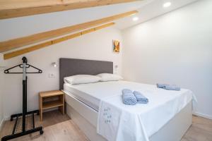 a bedroom with a white bed with blue towels on it at Apartmani Kralj in Dubrovnik